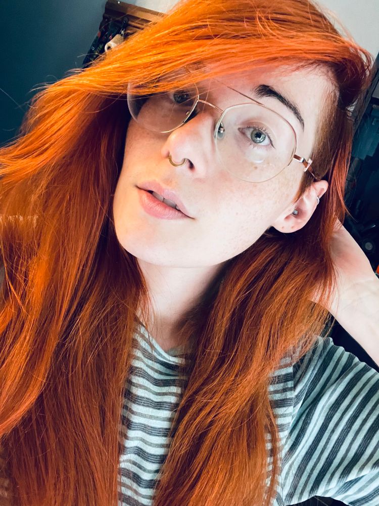A selfie of a befreckled Ruby in a green and grey striped shirt. 