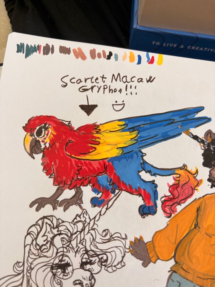 An acrylic marker drawing in a sketchbook of a gryphon based on a scarlet macaw.