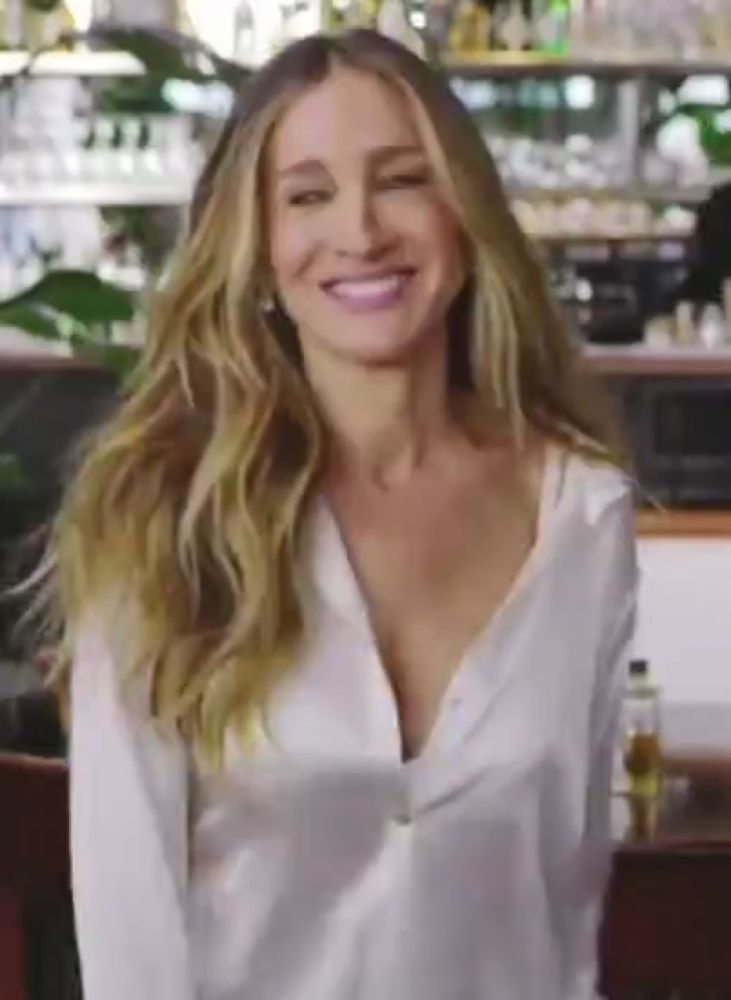 a woman wearing a white shirt is smiling and looking at the camera