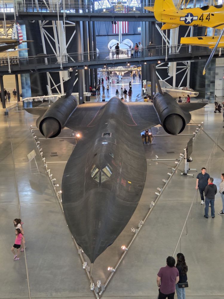 Foto de cima para baixo do Blackbird, um jato preto, com formato bem alongado al e arredondado