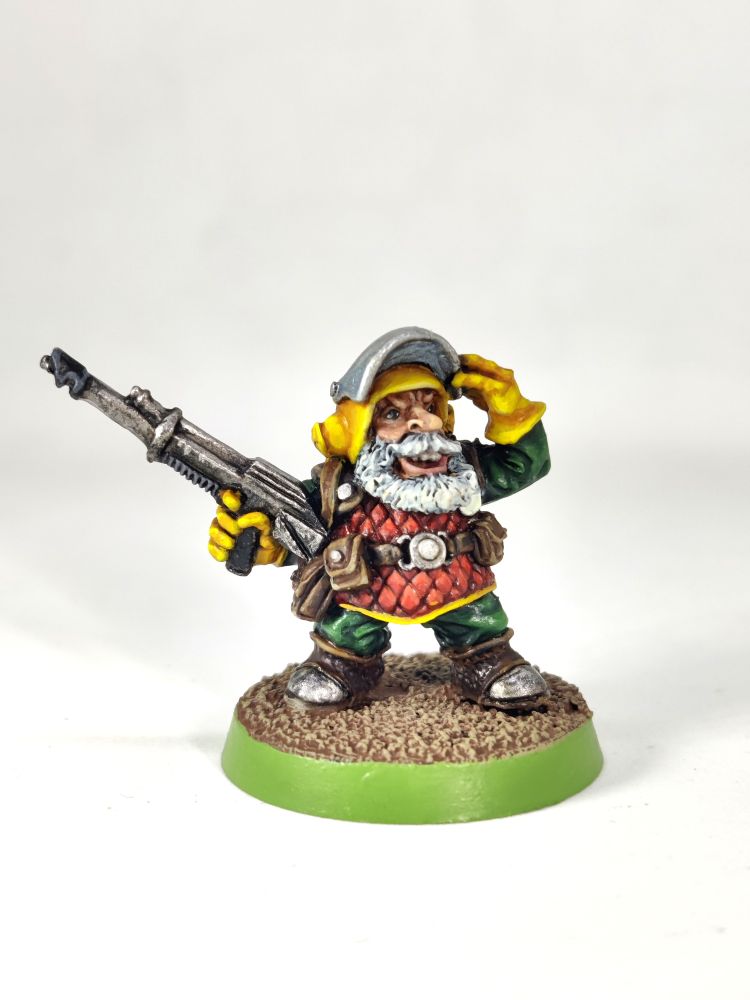 Photo of an old-school Rogue Trader-era Squat miniature (essentially a Space Dwarf) wearing red armour with a yellow helmet and white beard.