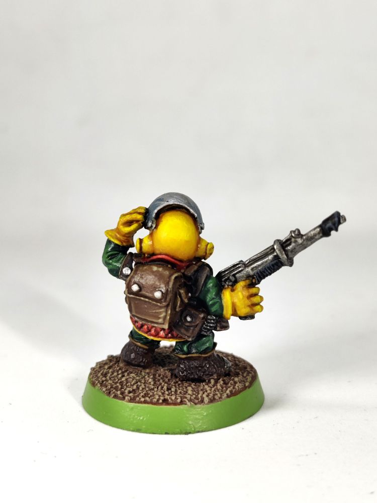 Photo of an old-school Rogue Trader-era Squat miniature (essentially a Space Dwarf) wearing red armour with a yellow helmet and white beard.