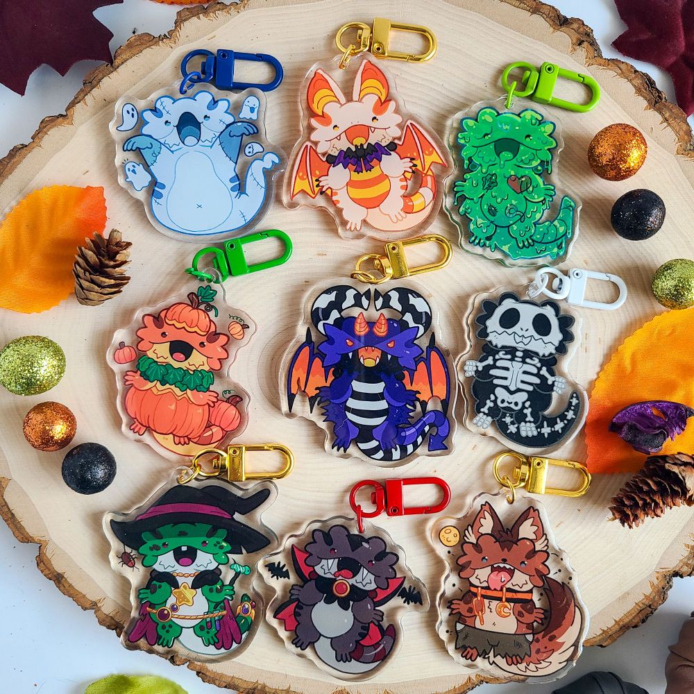 A set of 9 happy bearded dragons dressed up in costumes. There is a ghost, candy corn bat, slime, pumpkin, demon, skeleton, witch, vampire, and werewolf. 