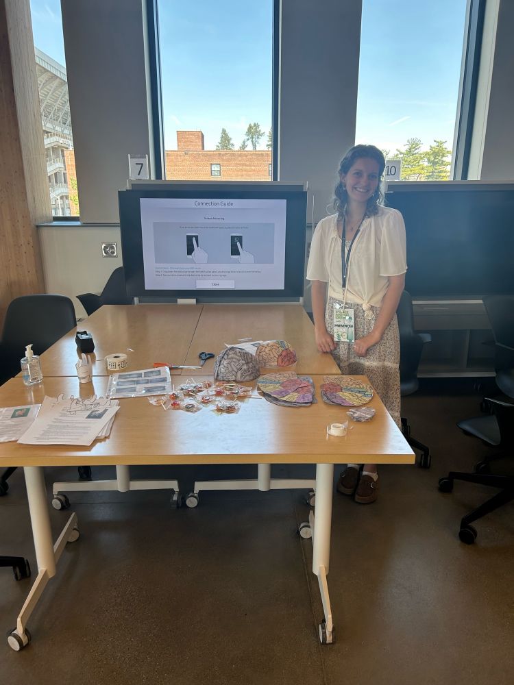 Brooke at the craft table ready to help the littles make a brain hat or paper larynx.