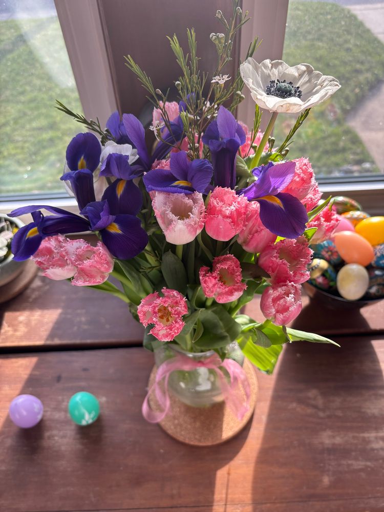 A flower bouquet on a window sill. 