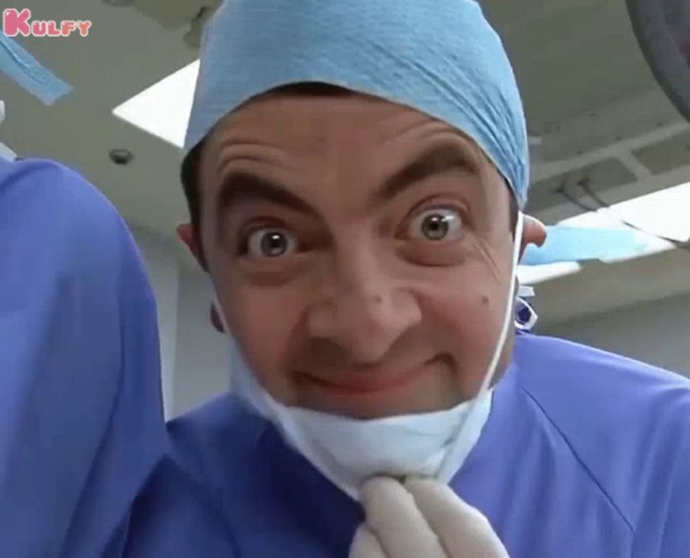 mr bean is wearing a surgical mask and tie .