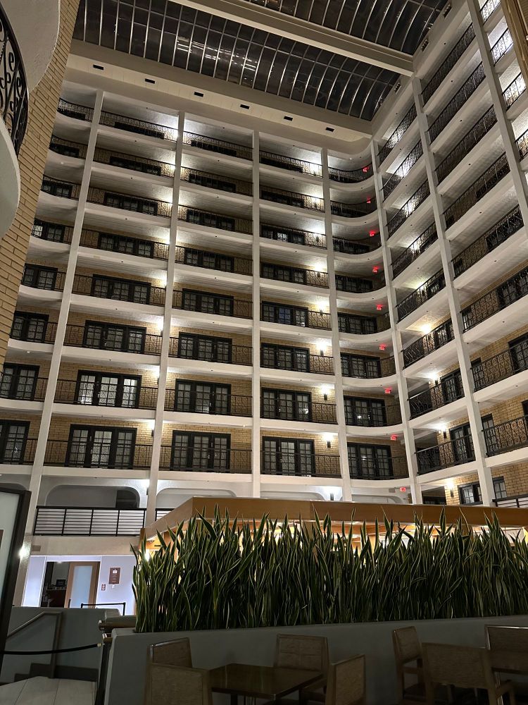 Upward shot of the interior lobby at the Embassy Suites by Hilton Austin Central, showing several floors of balconies leading to hotel rooms.