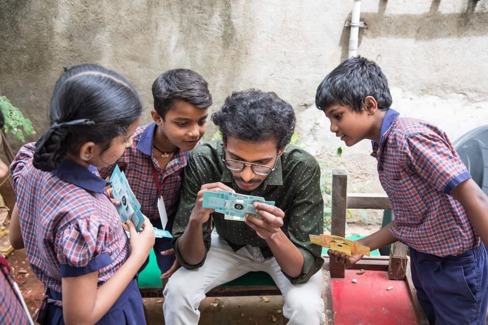 A.Santhos inserts a slide into the foldscope. He is a former student who lives in the neigbourhood and keeps in touch with the students of his alma mater, often taking them for nature walks to examine the world around them through the foldscope.
Viraj Nayer for NPR