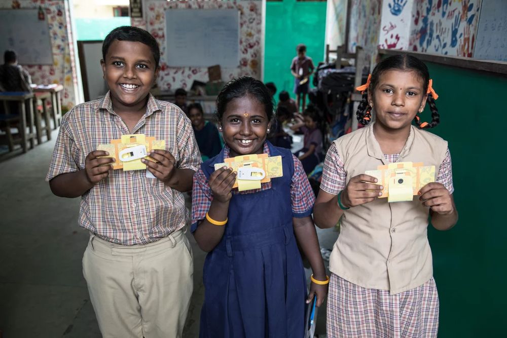 Ramana Rajeesh Kumar, 11, Meenakshi, 8, and Magathi Yazhini, 9, with their Foldscopes. Ramana has been fascinated with bugs for a while. "They look even cooler under the Foldscope," he says. "Especially their eyes and hairy feet!"  
Viraj Nayer for NPR
