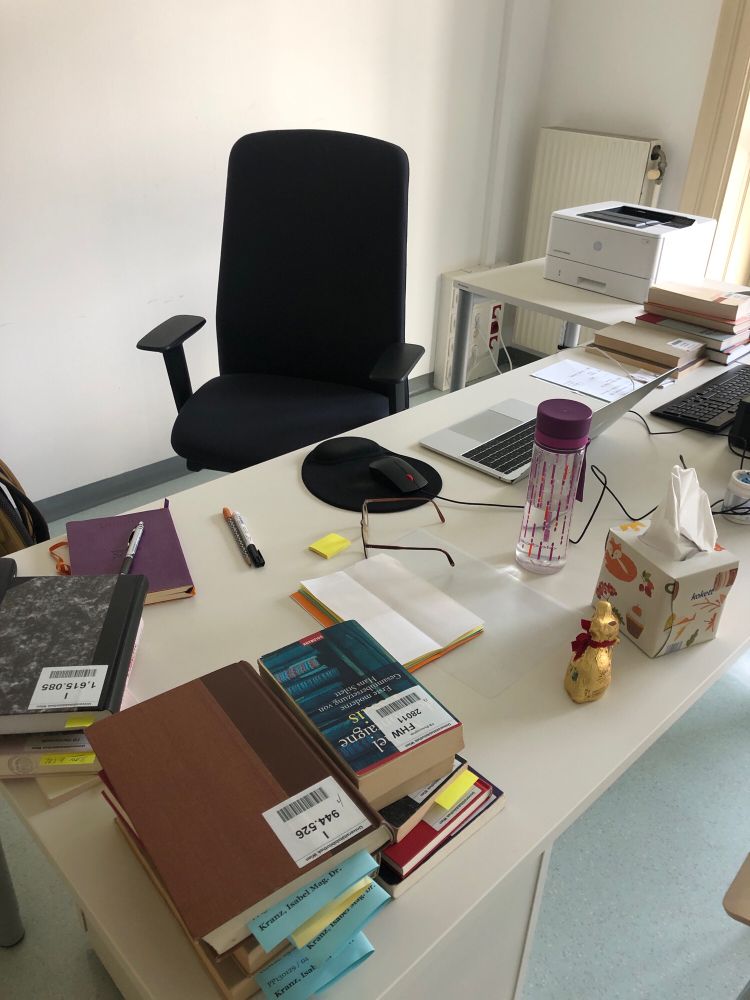 A work desk with books, a water bottle and a chocolate bunny