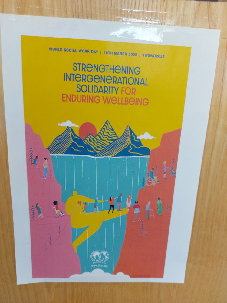 The picture is a poster for World Social Work Day which shows a person bridging a gap in a ravine which is allowing people of all ages and abilities to come together. 