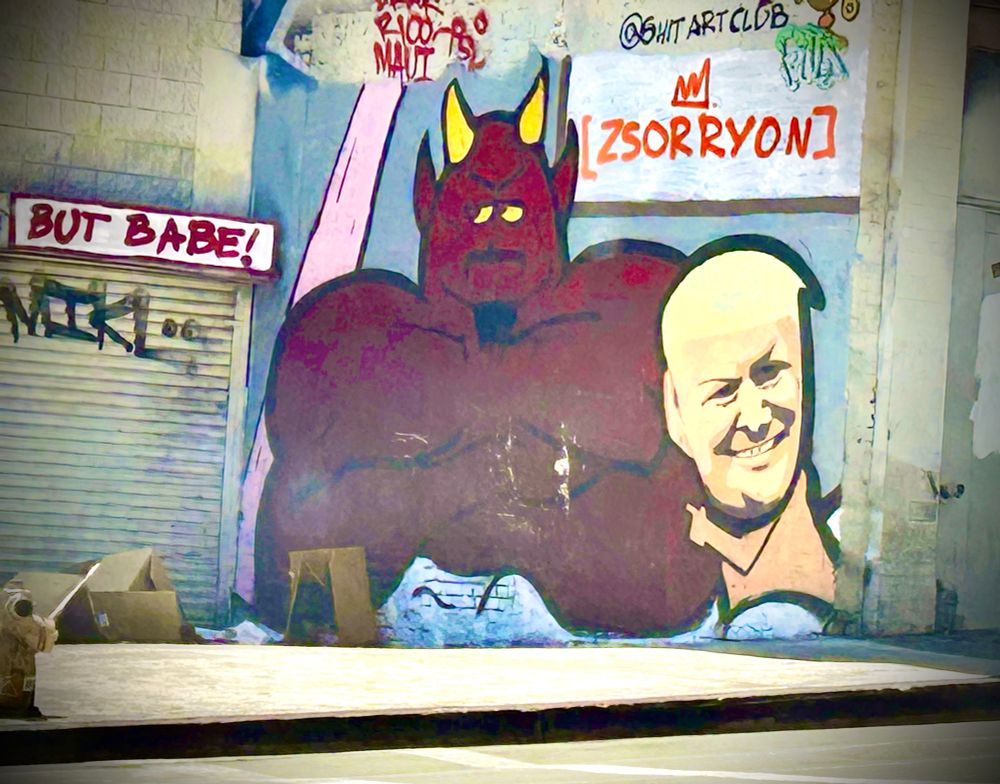 Photo of cartoon image of Trump and the devil from Southpark painted on a wall. 