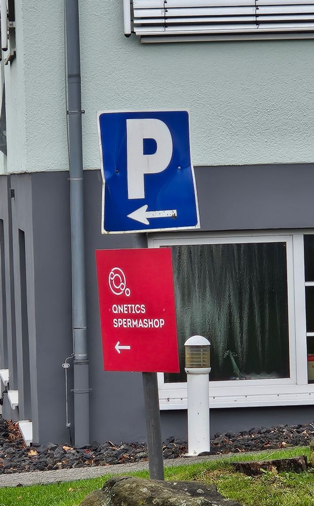 Schild unter Parkplatzschild "Qnetics Spermashop" 