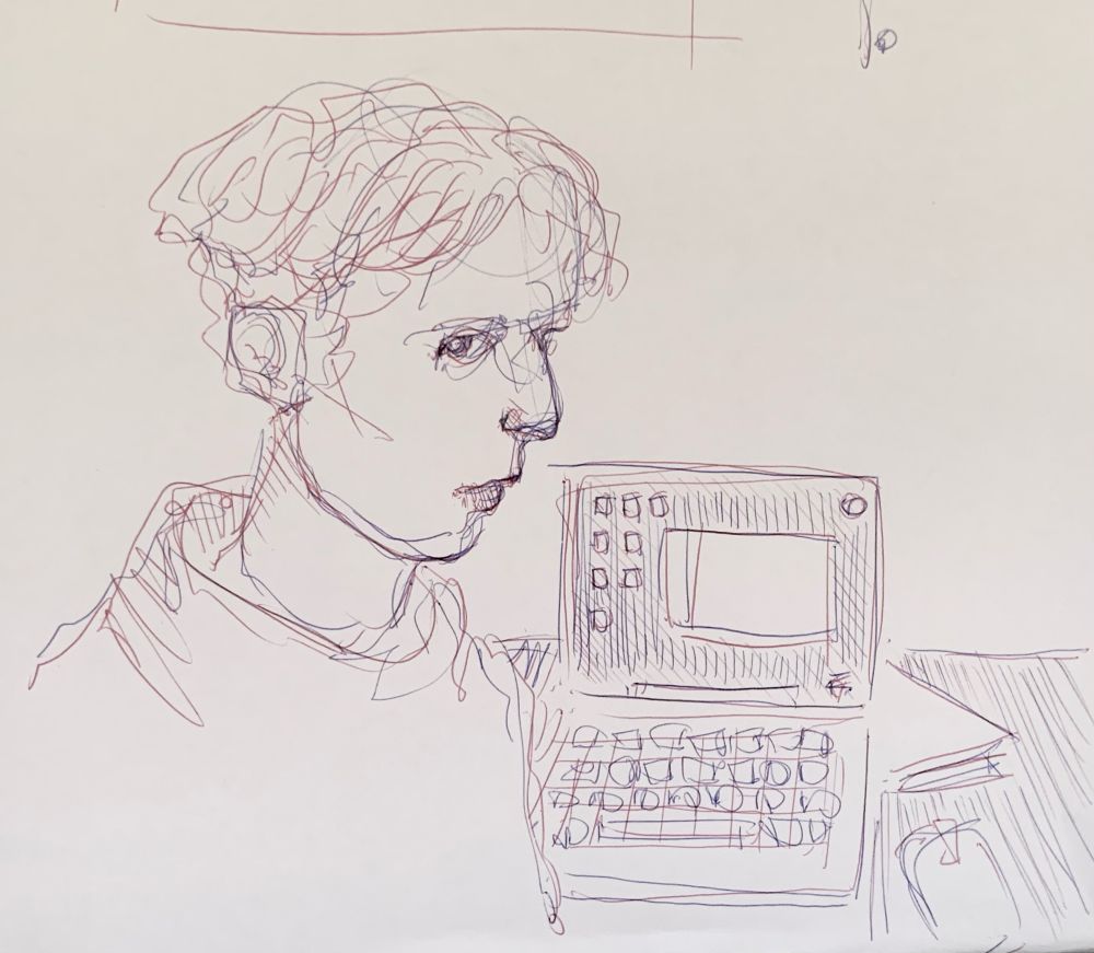 Visage tracé au stylo bille en fond une table, un ordinateur portable, un dossier.