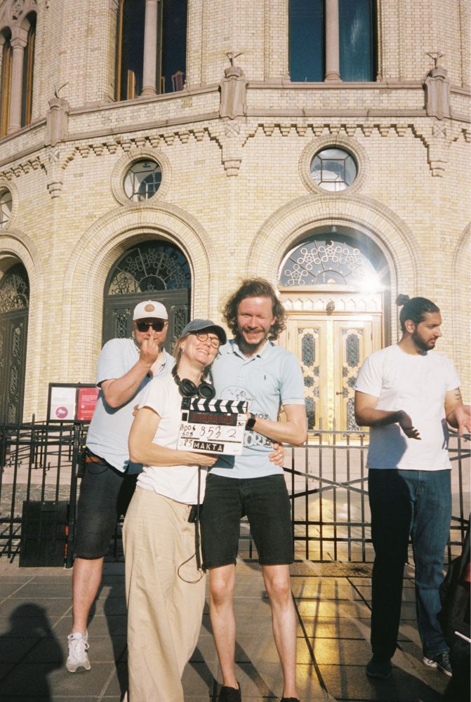 Regissør og fotograf poserer foran Stortinget etter siste bilde er tatt