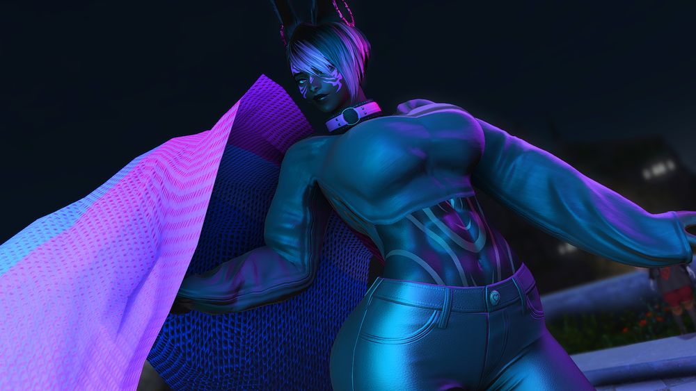 Rija, a Black Rava Viera, poses confidently with a bisexual flag tossed up above her hand. She is wearing a black top with black leather pants, and her hair is black with pink highlights.