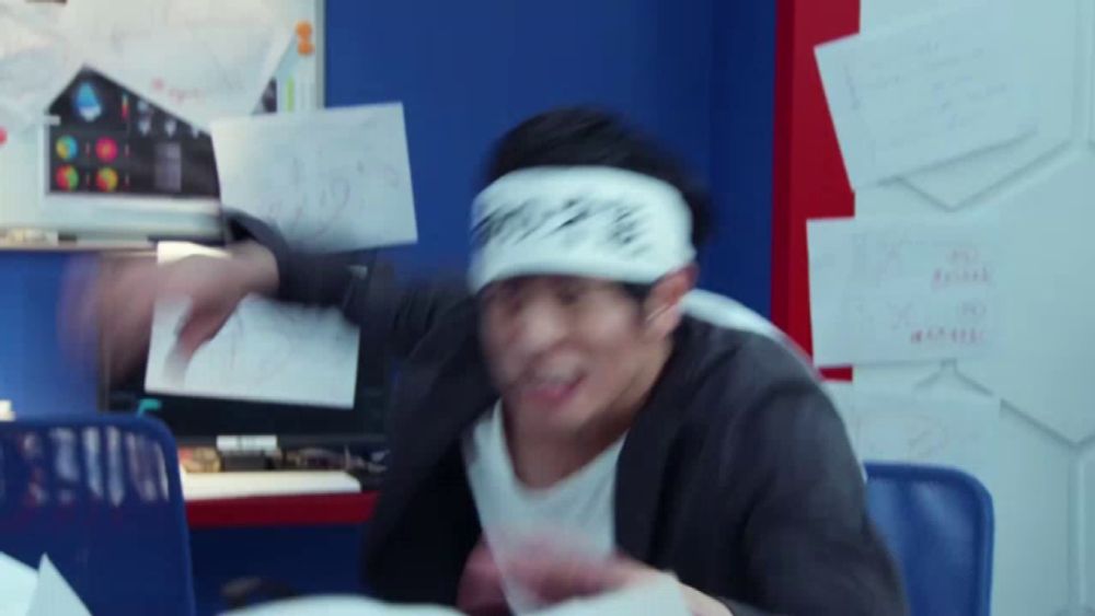 a man wearing a headband with chinese writing on it throws papers in the air