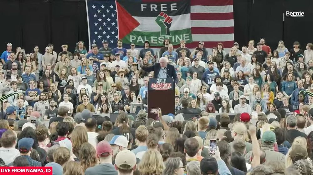 A large crowd in Idaho cheers as pro-Palestinian banner is unfurled over the American flag at a "fighting oligarchy" rally featuring Vermont Senator Bernie Sanders. The anti-genocide protesters were quickly arrested by local police on the orders of the Sanders' campaign. 