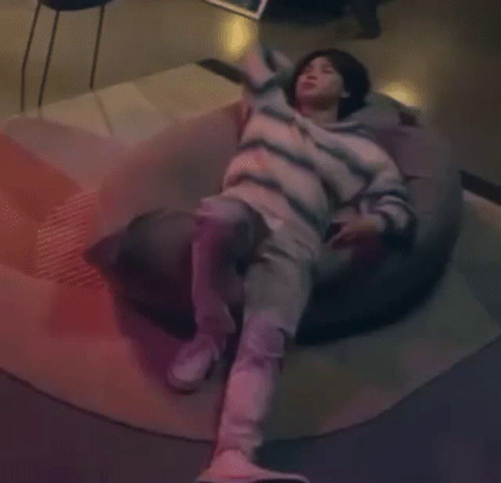 a person laying on a bean bag chair with their arms up