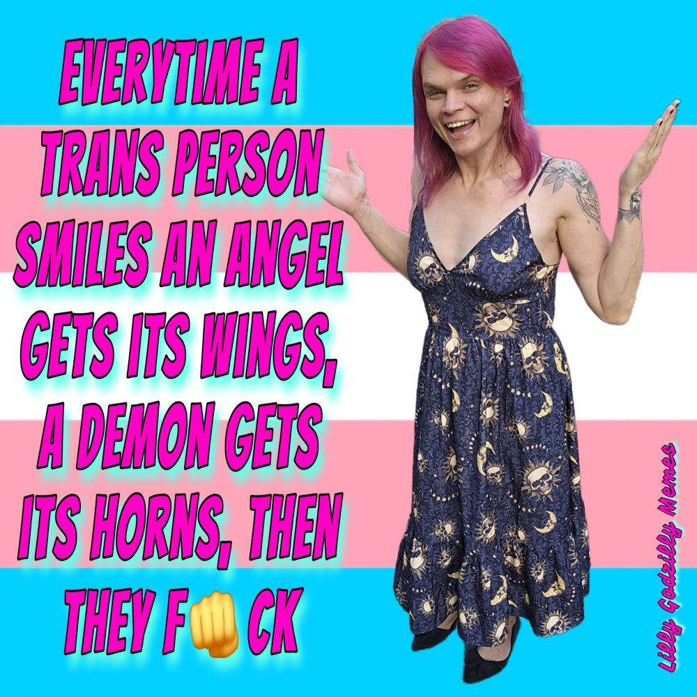 Image is a meme with a transpride pink, white and blue background and an image of Lilly Godzilly laughing

She has her arms out and is wearing a dark dress with yellow sun and moon patterns that have skulls inside them and black pointy toed shoes

She has pink hair and lacey flowery tattoos on her shoulder and wrist

 There's pink and blue text that reads, everytime a trans person smiles an angel gets its wings, a demon gets its horns, and then they f, fist emoji, ck 

The image is signed Lilly Godzilly Memes in pink and blue cursive font