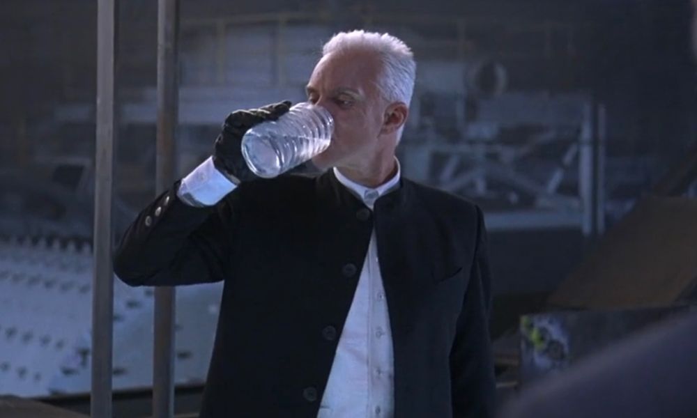 Tank Girl antagonist Kesslee drinking corpse water like a real Malcolm McDowell creep.