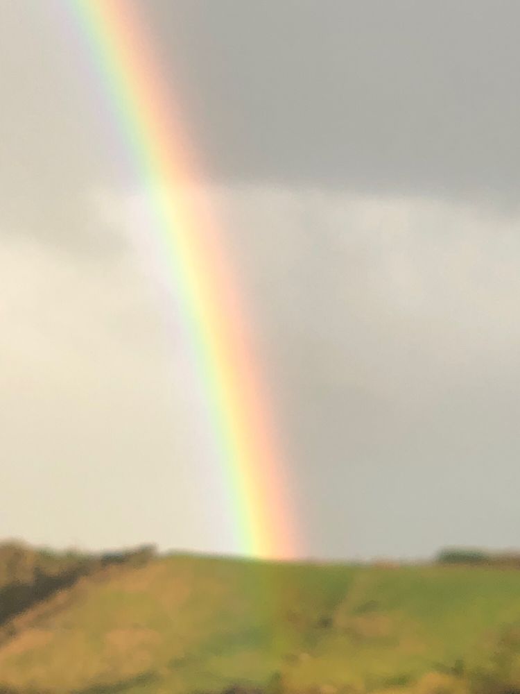 A bright end of a rainbow vividly displaying all its colours