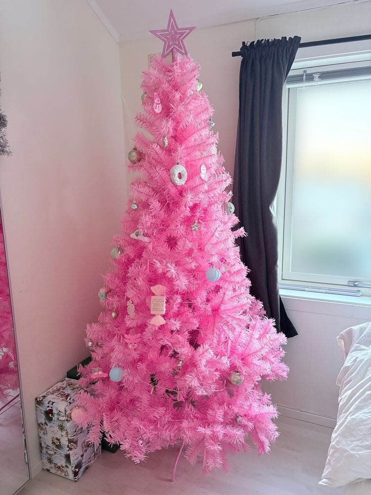 a pastel pink christmas tree with pastel ornaments