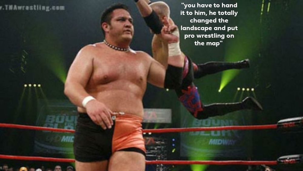 Samoa Joe walking out of the way of a diving wrestler, holding up his middle finger to him. The wrestler is saying "you have to hand it to him, he totally changed the landscape and put pro wrestling on the map" 