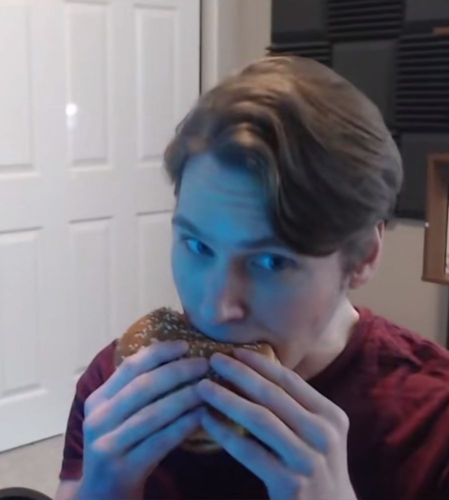Crazed lunatic eating a burger like a little lady