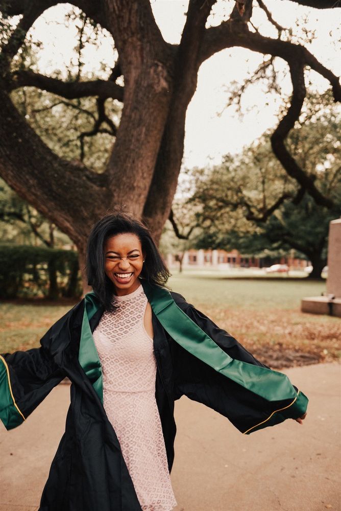 a photo of poet ari b. cofer on the baylor university campus in their graduation regalia 