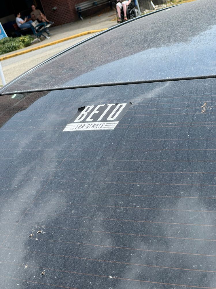 A sticker on the rear windshield of a car 