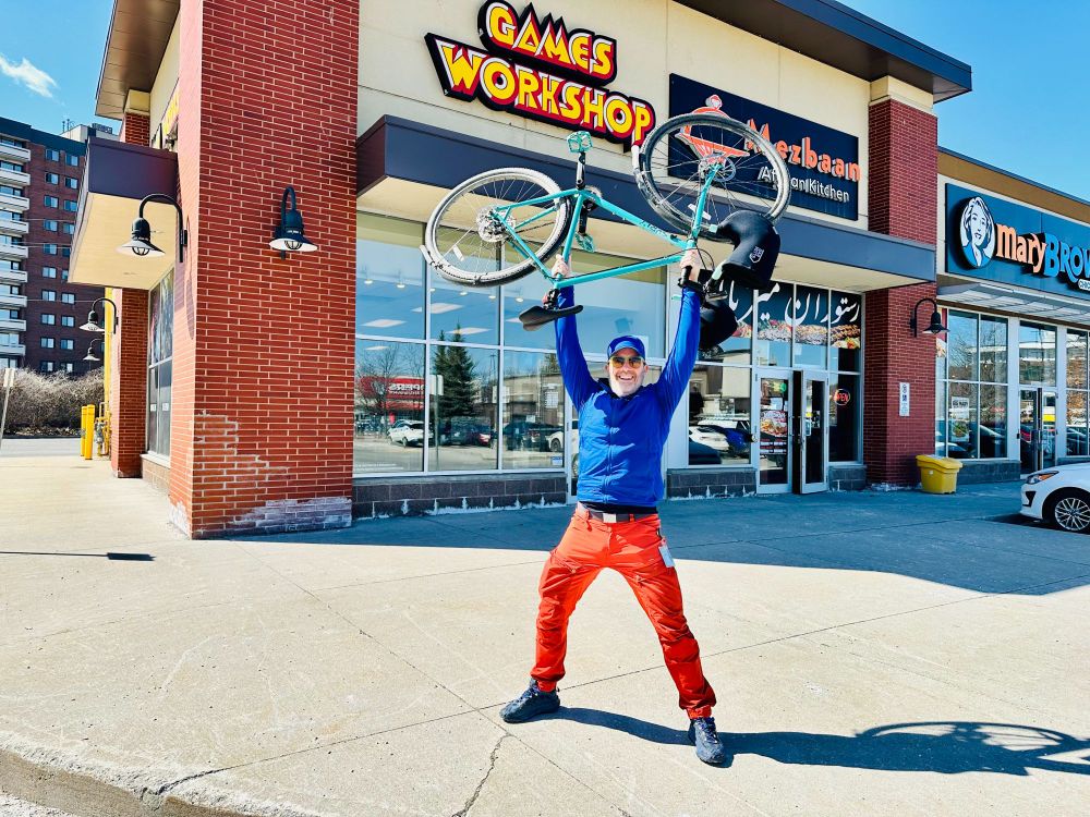 Yours truly in bright orange trousers holding my unstolen bike in the air triumphantly in front of Games Workshop!