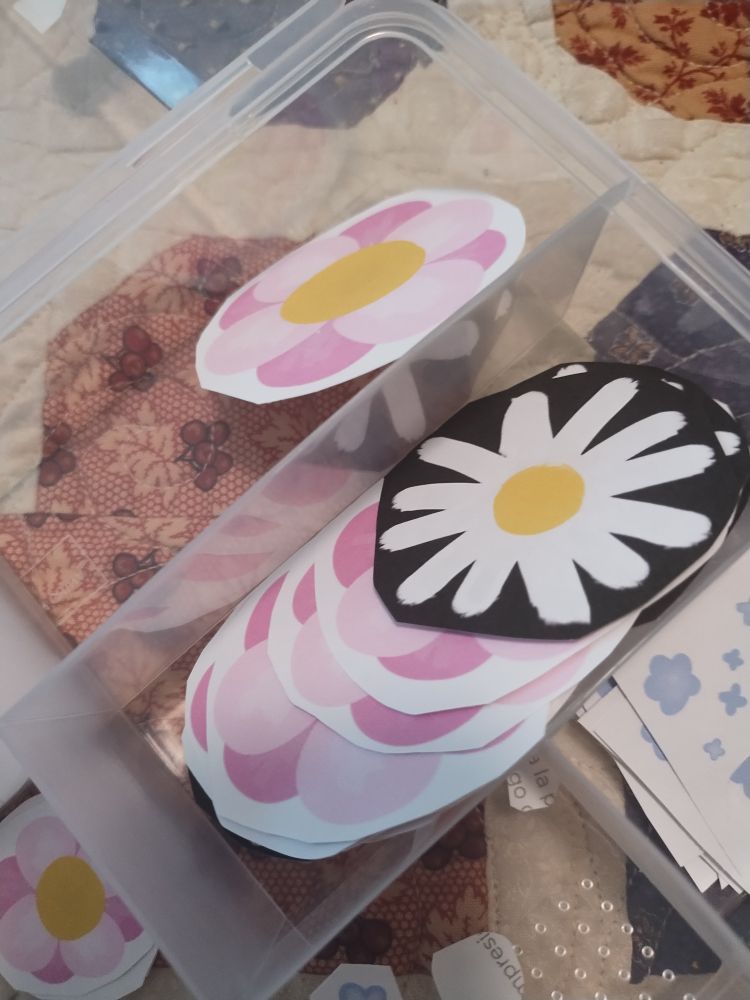 A small spread out pile of flower stickers. Most are pink flowers but one is a daisy