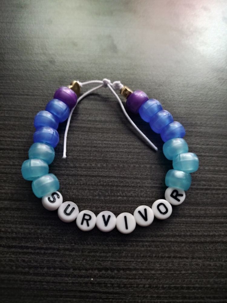 A light blue to purple gradient bracelet with the words "survivor" on it. (This is just an example of my bracelets. It's not one available.)