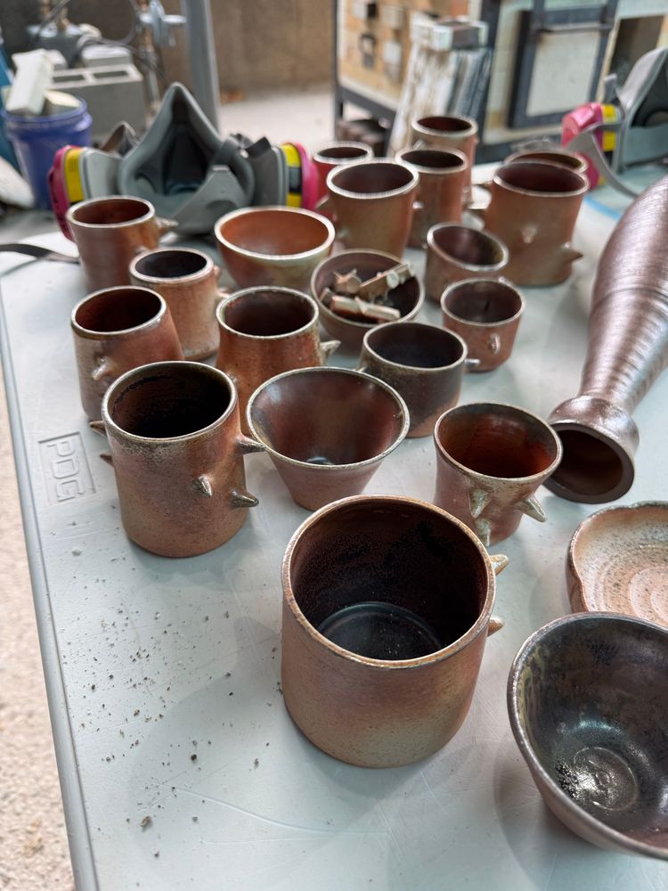 A close up of Marie’s Woodfire’s pieces - cups with ohata red interior 