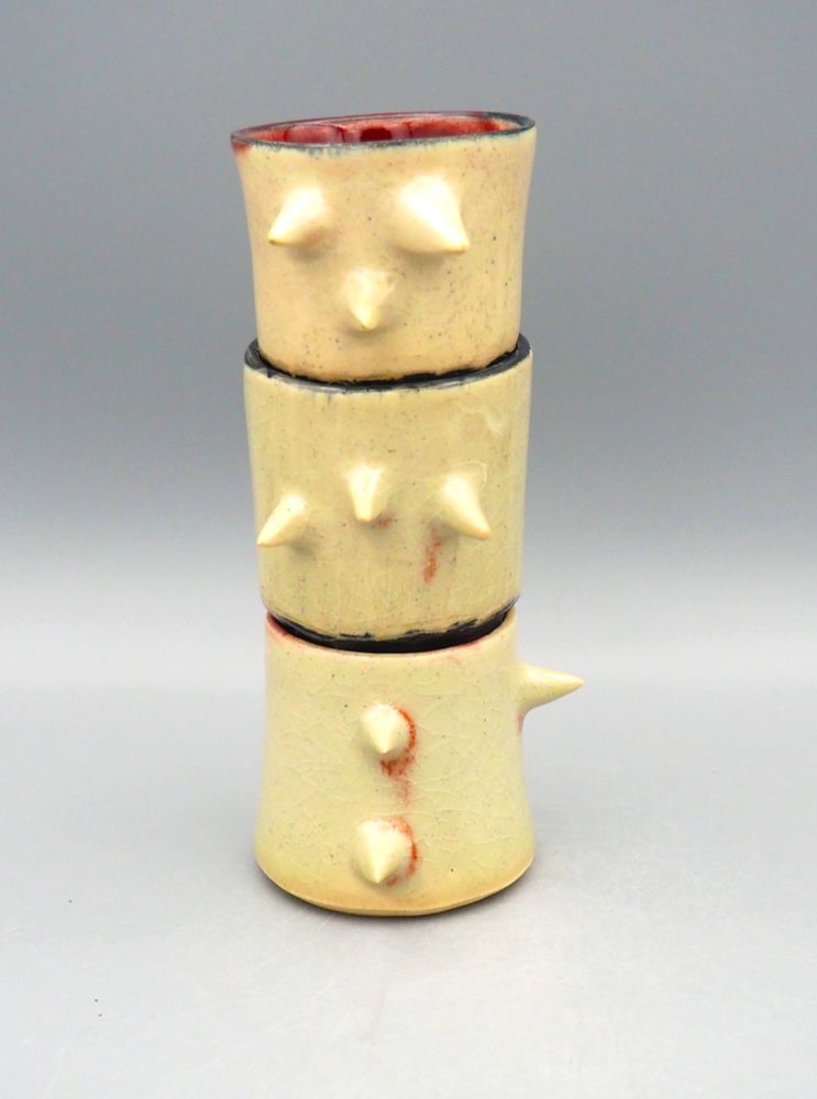 A set of three shot glasses stacked on top of each other - in oxblood and raspberry