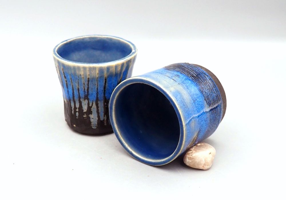 A photo of a shot glass and a tumbler in blue glaze