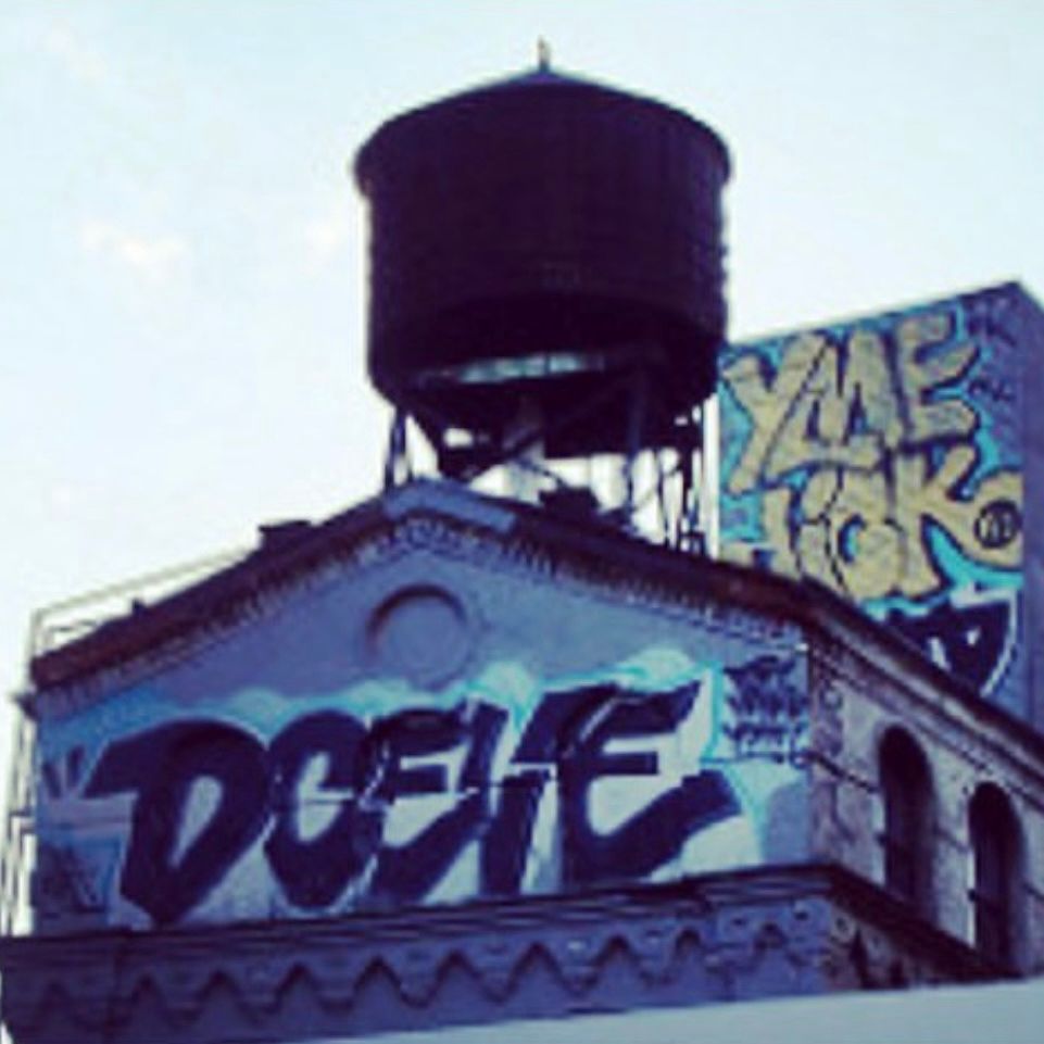 The top of a building in Chinatown Manhattan circa 1990s, with the classic ‘Brooklyn water tower’ and graffiti throwups/bombs from DCEIVE (lower level) and YME and Jick (above)