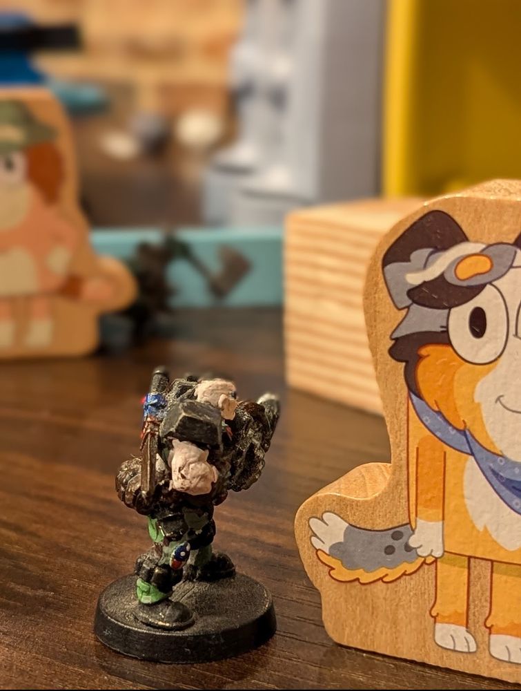 An armored space soldier standing next to a bluey play piece.  