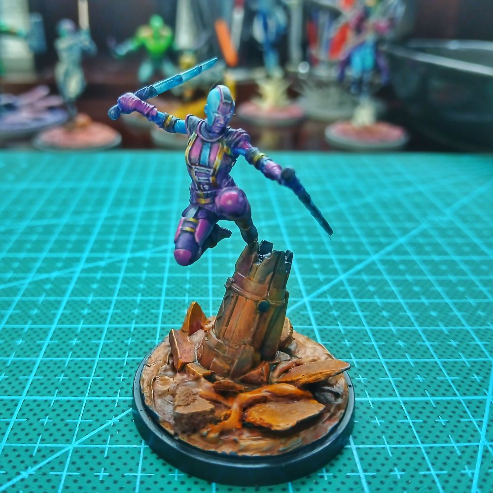 Small scale miniature of the marvel character nebula. A blue skinned cybernetic girl with violet and magenta armor. 