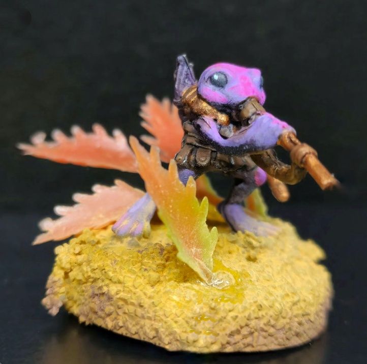 Little purple frog miniature, Hiding in leaf litter among a sandy base. 