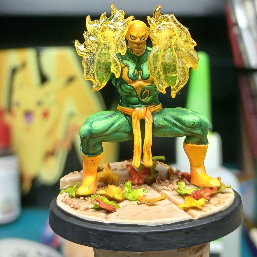 A painted miniature of Danny Rand, The iron fist. In his classic green and yellow costume. 
