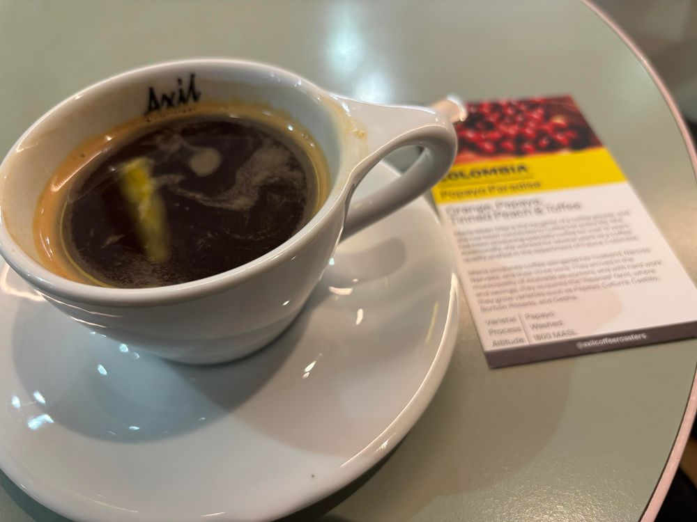 Cup of coffee with explanatory card detailing its Colombian origin. 