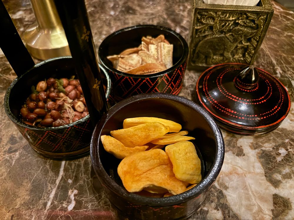 Colourful bar snacks in black and red bowls. 