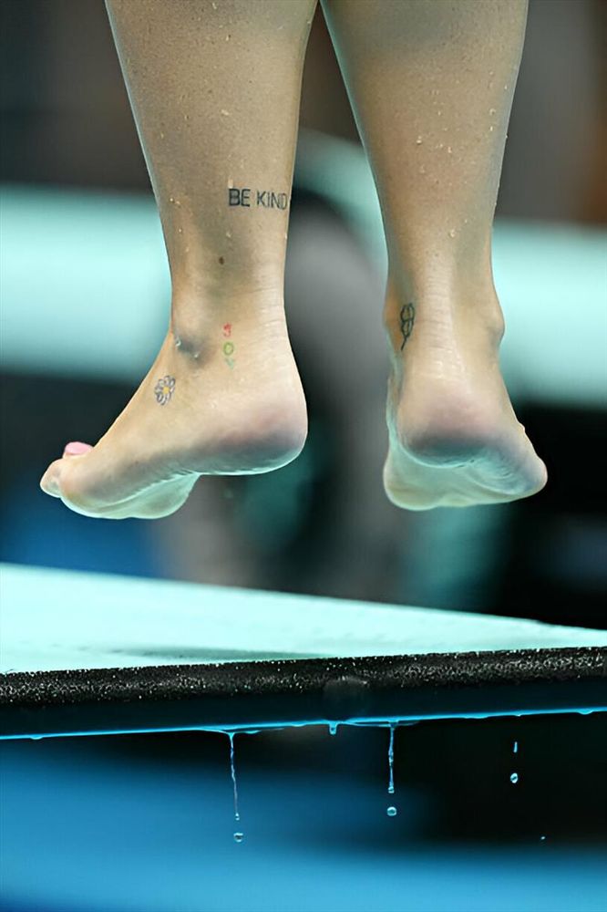 Foto da dietro ai piedi di  Chiara Pellacani mentre si sta tuffando dal trampolino. Ai piedi e alle caviglie ha dei piccoli tatuaggi.
