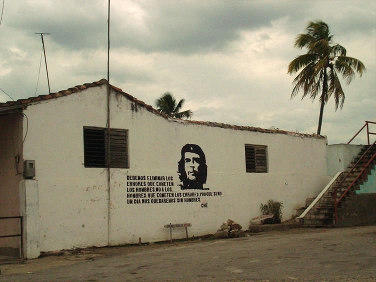 Foto all'esterno di un casa a un piano dove c'è un murales con il volto del Che e la scritta "Dobbiamo eliminare gli errori che commettono gli uomini, non gli uomini che commettono gli errori, perché se no un giorno rimarremo senza uomini", in spagnolo.