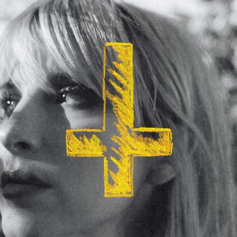 Primo piano ad Hayley Williams leggermente di profilo. Disegnato di giallo sulla foto c'è una croce alla rovescia.