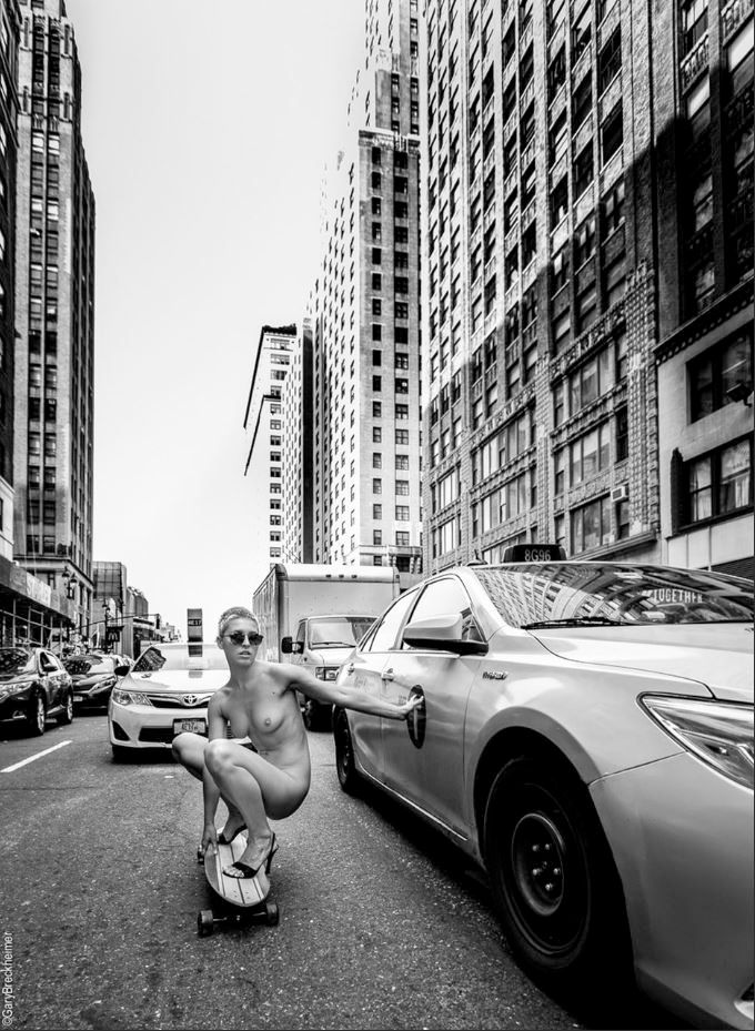 Marisa Papen nuda che fa skate, rannicchiata, sulle strade di New York, tra le macchine in coda.