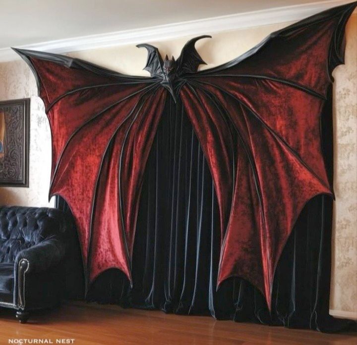 Foto a una tenda, o una sovratenda, non so come chiamarla, è una tenda amaranto a forma di pipistrello, davanti a una tenda nera, messa in una sala.