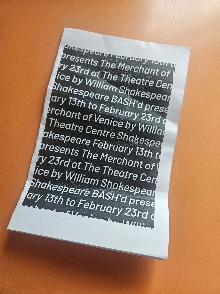 On an orange background lies a show programme for Shakespeare BASH'd's THE MERCHANT OF VENICE, directed by Julia Nish-Lapidus, running February 13 to February 23rd at The Theatre Centre. The run is technically Sold Out, but there have been empty rush seats at every show, including 10 at the performance I attended. If you don't have a ticket, rush it; I gave it only my 2nd standing ovation of 2025. 